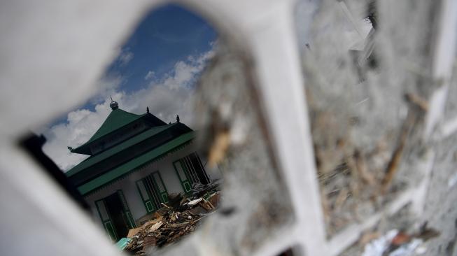 Suasana Masjid Al Amin diantara bangunan yang rusak akibat gempa dan tsunami di Wani, Donggala, Sulawesi Tengah, Minggu (14/10). [ANTARA FOTO/Wahyu Putro] 