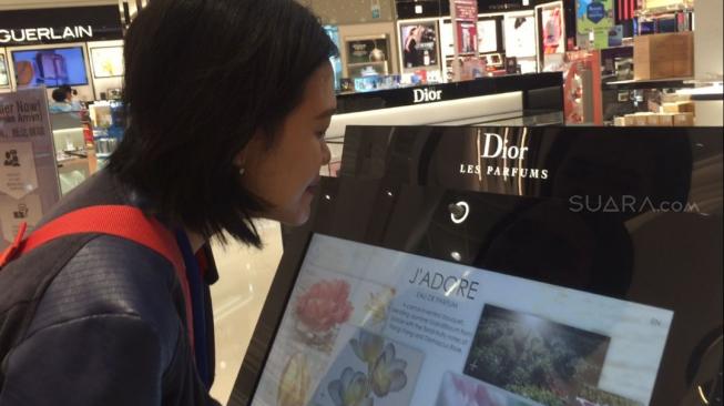 Mencium aroma parfum dari LCD touch screen di The Shilla Duty Free, Bandara Changi. (Suara.com/Sumarni)