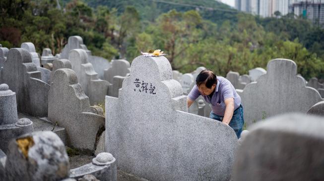 Warga mengunjungi makam kerabat saat Festival Chung Yeung atau juga dikenal Tomb Sweeping Day di sebuah pemakaman di Hong Kong, Rabu (17/10). [AFP/Anthony WALLACE]