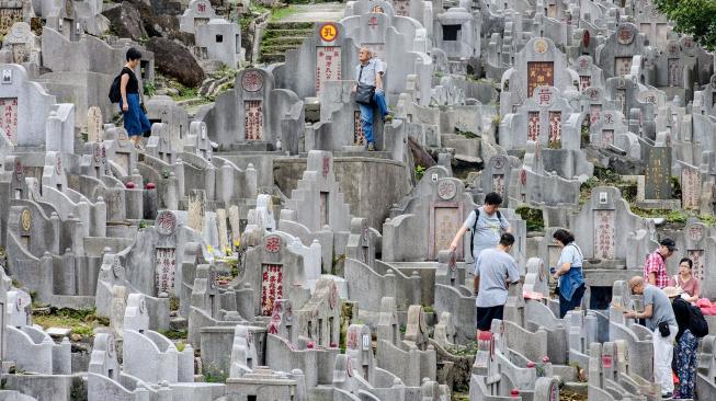 Warga mengunjungi makam kerabat saat Festival Chung Yeung atau juga dikenal Tomb Sweeping Day di sebuah pemakaman di Hong Kong, Rabu (17/10). [AFP/Anthony WALLACE]