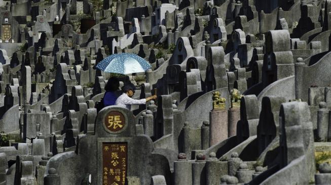 Warga mengunjungi makam kerabat saat Festival Chung Yeung atau juga dikenal Tomb Sweeping Day di sebuah pemakaman di Hong Kong, Rabu (17/10). [AFP/Anthony WALLACE]