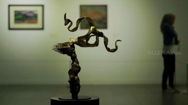 Pengunjung mengamati sejumlah karya saat pameran seni yang bertajuk 'Menyigi Masa' di Galeri Nasional, Jakarta, Kamis (18/10). [Suara.com/Muhaimin A Untung]