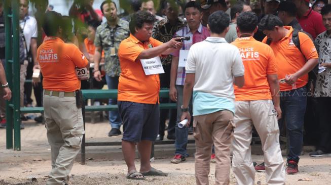 Tersangka mencontohkan menembak saat melakukan gelar rekonstruksi terkait kasus peluru nyasar gedung DPR RI di Lapangan Tembak, Senayan, Jakarta, Jumat (19/10). [Suara.com/Muhaimin A Untung]