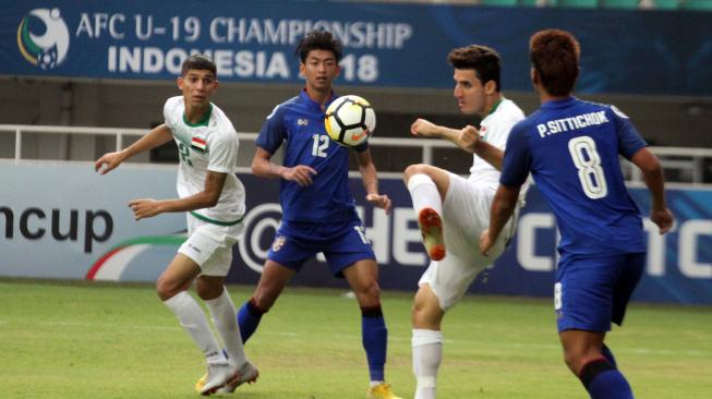 Pemain Timnas Iraq Abbas Badeea (kedua kanan) dibayangi dua pemain Timnas Thailand dalam laga Grup B Piala Asia U-19 di Stadion Pakansari, Bogor, Jawa Barat, Jumat (19/10/2018). Pertandingan tersebut berakhir imbang 3-3. ANTARA FOTO/Yulius Satria Wijaya