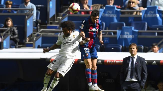 Bek Real Madrid Marcelo dan pemain depan Levante, Jason Remeseiro, melompat untuk memperebutkan bola selama pertandingan sepak bola liga Spanyol Real Madrid melawan Levante di Stadion Santiago Bernabeu, Madrid, Spanyol, Sabtu (20/10). [AFP/GABRIEL BOUYS]