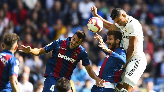 Bek Levante, Roberto Suarez Pier dan gelandang Real Madrid, Casemiro melompat untuk memperebutkan bola selama pertandingan sepak bola liga Spanyol Real Madrid melawan Levante di Stadion Santiago Bernabeu, Madrid, Spanyol, Sabtu (20/10). [AFP/GABRIEL BOUYS]