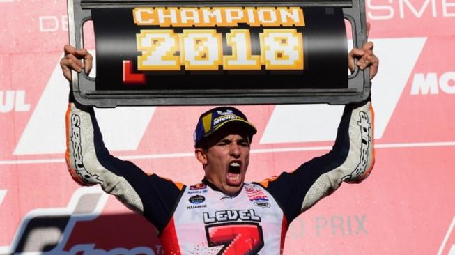 Pebalap Repsol Honda, Marc Marquez, merayakan kesuksesan menjadi juara dunia MotoGP 2018 usai memenangi balapan MotoGP Jepang di Sirkuit Motegi, Minggu (21/10/2018). [AFP/Martin Bureau]