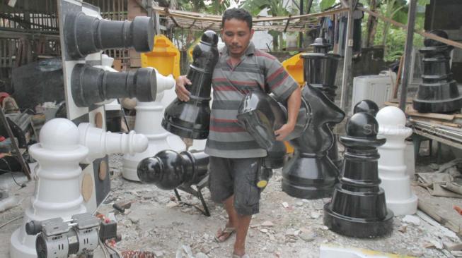 Pengrajin saat membuat bidak Catur raksasa di Pondok Aren, Tangerang Selatan, Senin (22/10). (Suara.com/Fakhri Hermansyah)