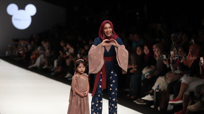 Desainer Jenehara bersama anaknya tampil saat perinhati hari jadi Mickey Mouse ke-90 di Jakarta Fashion Week 2019 di Senayan City, Jakarta, Senin (22/10). [Suara.com/Muhaimin A Untung]