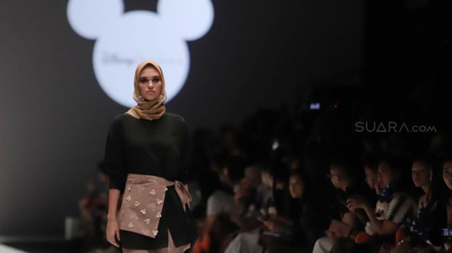 Model mengenakan pakaian rancangan desain Suqma saat hari jadi Mickey Mouse ke-90 di Jakarta Fashion Week 2019 di Senayan City, Jakarta, Senin (22/10). [Suara.com/Muhaimin A Untung]