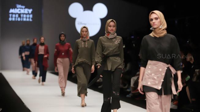 Model mengenakan pakaian rancangan desain Suqma saat hari jadi Mickey Mouse ke-90 di Jakarta Fashion Week 2019 di Senayan City, Jakarta, Senin (22/10). [Suara.com/Muhaimin A Untung]