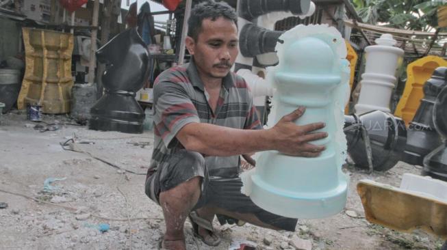 Pengrajin saat membuat bidak Catur raksasa di Pondok Aren, Tangerang Selatan, Senin (22/10). (Suara.com/Fakhri Hermansyah)