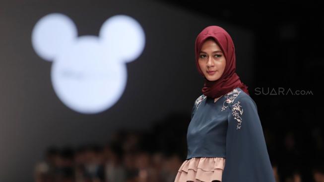 Model mengenakan pakaian rancangan desain Suqma saat hari jadi Mickey Mouse ke-90 di Jakarta Fashion Week 2019 di Senayan City, Jakarta, Senin (22/10). [Suara.com/Muhaimin A Untung]