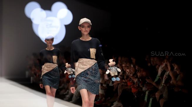 Model mengenakan pakaian rancangan desainer Didiet Maulana dari IKAT Indonesia saat peragaan busana Disney's Mickey Mouse: The True Orginal di Jakarta Fashion Week 2019 di Senayan City, Jakarta, Senin (22/10). [Suara.com/Muhaimin A Untung]