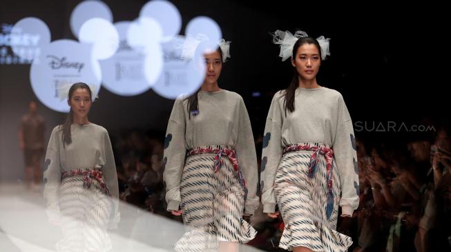 Model mengenakan pakaian rancangan desainer Didiet Maulana dari IKAT Indonesia saat peragaan busana Disney's Mickey Mouse: The True Orginal di Jakarta Fashion Week 2019 di Senayan City, Jakarta, Senin (22/10). [Suara.com/Muhaimin A Untung]