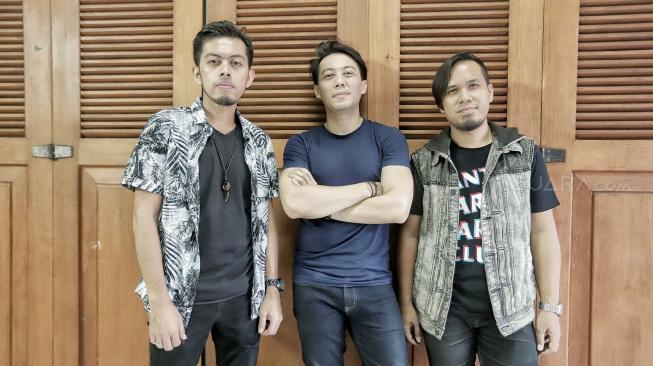 Personil Band Drive Rizki (vokal), Budi Rahardjo (gitaris) dan Ilhamsyah Dyego Pratama (bassist) berpose saat kunjungan ke kantor redaksi Suara.com, Jakarta, Rabu (24/10). [Suara.com/Muhaimin A Untung] 