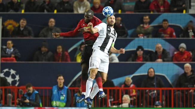 Striker Manchester United Romelu Lukaku berduel memperebutkan bola dengan bek Juventus  Giorgio Chiellini selama pertandingan sepak bola grup H Liga Champions antara Manchester United melawan Juventus di Old Trafford, Manchester, Inggris, Selasa (23/10).  [AFP/Oli SCARFF]
