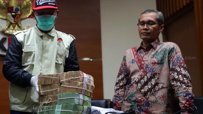 Wakil Ketua KPK Alexander Marwata menyaksikan penyidik KPK menunjukan barang bukti uang hasil operasi tangkap tangan (OTT) di Kabupaten Cirebon saat konferensi pers di gedung KPK, Jakarta, Kamis (25/10). [Suara.com/Muhaimin A Untung]