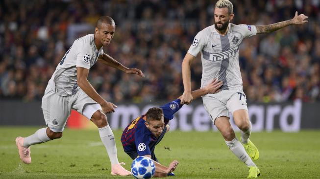 Pemain tengah Barcelona  Arthur bersaing untuk mendapatkan bola dengan gelandang Inter Milan, Marcelo Brozovic dan bek Inter Milan Joao Miranda  selama pertandingan Grup B Liga Champions Barcelona melawan Inter Milan di Stadion  Camp Nou, Barcelona, Spanyol, Rabu (24/10).  (AFP/Josep LAGO)