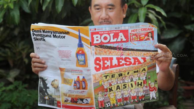 Warga membaca Tabloid Olahraga Bola edisi terakhir di Duren Sawit, Jakarta, Jumat (26/10). (Suara.com Fakhri Hermansyah)