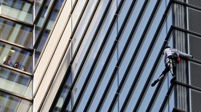 Pendaki Prancis Alain Robert, yang juga dikenal sebagai "Spider-Man", memanjat bagian Menara Heron di distrik keuangan London, Inggris, Kamis (25/10). [AFP/Daniel LEAL-OLIVAS]