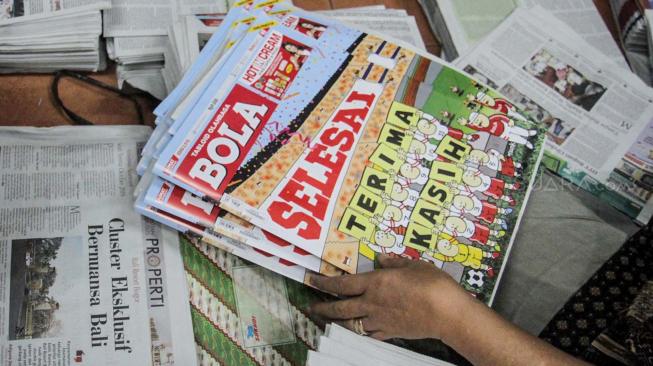 Tabloid Olahraga Bola edisi terakhir di lapak penjual koran kawasan Duren Sawit, Jakarta, Jumat (26/10).(Suara.com/Fakhri Hermansyah)