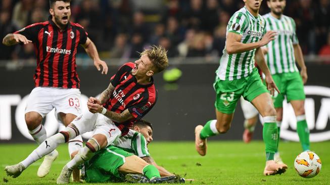 Pemain depan AC Milan Samuel Castillejo dihadang oleh bek Real Betis selama pertandingan Grup F Liga Europa antara AC Milan melawan Real Betis di Stadion San Siro, Milan, Italia, Kamis (25/10). [AFP/Miguel MEDINA]