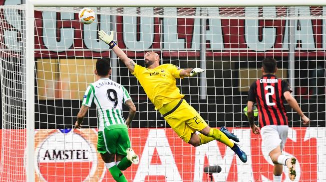 Penjaga gawang AC Milan Pepe Reina gagal menghentikan tembakan dari pemain tengah Real Betis Giovani Lo Celso selama pertandingan Grup F Liga Europa antara AC Milan melawan Real Betis di Stadion San Siro, Milan, Italia, Kamis (25/10). [AFP/Miguel MEDINA]
