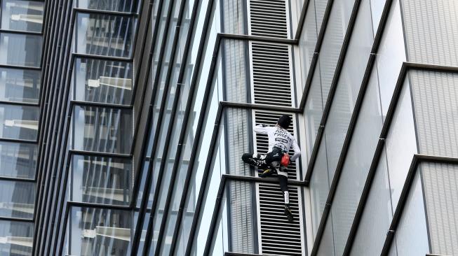 Pendaki Prancis Alain Robert, yang juga dikenal sebagai "Spider-Man", memanjat bagian Menara Heron di distrik keuangan London, Inggris, Kamis (25/10). [AFP/Daniel LEAL-OLIVAS]