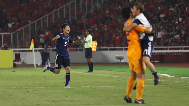 Pesepak bola Indonesia Hanis Saghara Putra berebut bola dengan pesepak bola Jepang Daiki Hashioka dalam babak perempat final Piala Asia U-19 di Stadion Utama Gelora Bung Karno, Senayan, Jakarta, Minggu (28/10/2018). [Suara.com/Muhaimin A Untung]