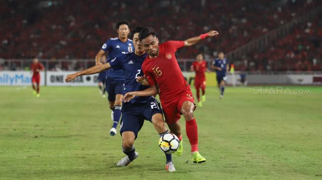 Pesepak bola Indonesia Sadil Ramdani berebut bola dengan pesepak bola Jepang Taisei Miyashiro dalam babak perempat final Piala Asia U-19 di Stadion Utama Gelora Bung Karno, Senayan, Jakarta, Minggu (28/10/2018). [Suara.com/Muhaimin A Untung]