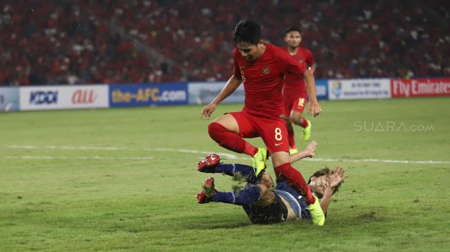 Pesepak bola Indonesia Witan Sulaiman berusaha menghindar dari pesepak bola Jepang dalam babak perempat final Piala Asia U-19 di Stadion Utama Gelora Bung Karno, Senayan, Jakarta, Minggu (28/10/2018). [Suara.com/Muhaimin A Untung]