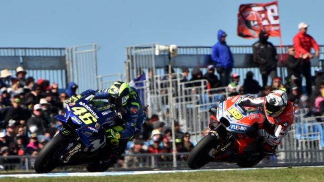 Pebalap Movistar Yamaha, Valentino Rossi (kiri), berada di depan pebalap Ducati, Alvaro Bautista, dalam balapan MotoGP Australia di Sirkuit Phillip Island, Minggu (28/10/2018). [AFP/Paul Crock]