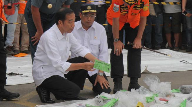 Presiden Joko Widodo bersama Kepala Basarnas Marsekal Madya Muhammad Syaugi  dan Menteri Perhubungan Budi Karya Sumadi saat melihat puing-puing pesawat Lion Air JT-610 di Pelabuhan Tanjung Priok, Jakarta, Selasa (30/10). (Suara.com/Fakhri Hermansyah)