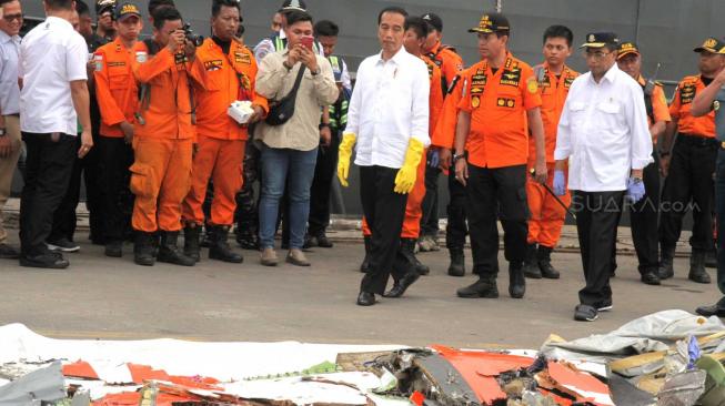 Presiden Joko Widodo bersama Kepala Basarnas Marsekal Madya Muhammad Syaugi  dan Menteri Perhubungan Budi Karya Sumadi saat melihat puing-puing pesawat Lion Air JT-610 di Pelabuhan Tanjung Priok, Jakarta, Selasa (30/10). (Suara.com/Fakhri Hermansyah)