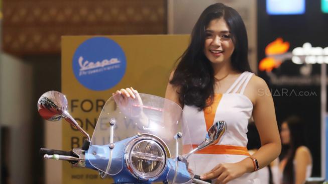 Sales Promotion Girls (SPG) atau model bersanding di samping motor pada pembukaan Indonesia Motorcycle Show (IMOS)2018 diikuti sejumlah produsen kendaraan  2018, JCC Senayan,  Jakarta, Rabu (31/10). [Suara.com/Muhaimin A Untung] 