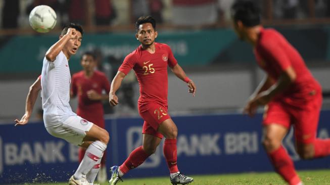 Pesepak bola Timnas Indonesia Andik Vermansyah (tengah) mengumpan bola ke rekannya Irfan Jaya (kanan) saat melewati pesepak bola Timnas Hong Kong Yang Huang (kiri) dalam laga International Friendly Match di Stadion Wibawa Mukti, Cikarang, Bekasi, Jawa Barat, Selasa (16/10/2018). Pertandingan tersebut berakhir imbang dengan skor 1 - 1. ANTARA FOTO/Hafidz Mubarak A