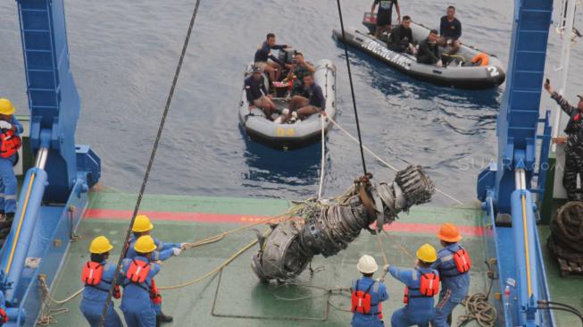 Petugas  kapal Baruna Jaya 1 mengangkat mesin turbin pesawat Lion Air JT 610  yang ditemukan oleh tim penyelam TNI AL Dislambair di perairan Karawang, Jawa Barat, Sabtu (3/11). (Suara.com/Fakhri Hermansyah)