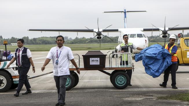 Petugas cargo membawa peti Jenazah korban jatuhnya pesawat Lion Air JT 610 Chandra Kirana saat tiba diterminal cargo Bandara Sultan Mahmud Baddarudin (SMB) II Palembang, Sumatera Selatan, Sabtu (3/11). [ANTARA FOTO/Nova Wahyudi]