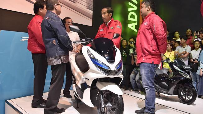 Presiden Joko Widodo (kedua kanan) mengamati motor listrik pada pameran Indonesia Motorcycle Show (IMOS) 2018 di Jakarta Convention Center, Jakarta, Sabtu (3/11).  [ANTARA FOTO/Puspa Perwitasari]