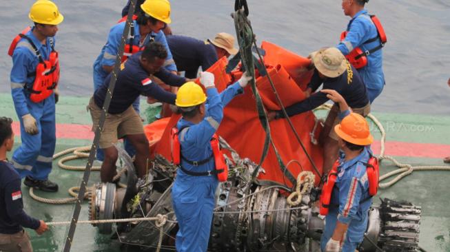 Petugas  kapal Baruna Jaya 1 mengangkat mesin turbin pesawat Lion Air JT 610  yang ditemukan oleh tim penyelam TNI AL Dislambair di perairan Karawang, Jawa Barat, Sabtu (3/11). (Suara.com/Fakhri Hermansyah)