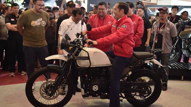 Presiden Joko Widodo mencoba motor Royal Enfield saat mengunjungi Indonesia Motorcycle Show (IMOS) 2018 di Jakarta Convention Center, Jakarta, Sabtu (3/11). [ANTARA FOTO/Puspa Perwitasari]