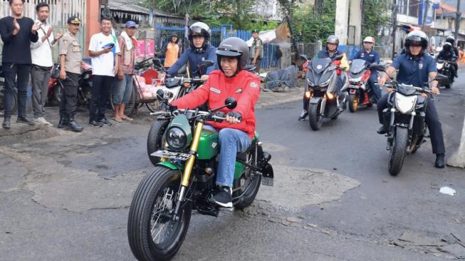 Presiden Joko Widodo mengendarai motor menuju Pasar Anyar, Tangerang, Banten, Minggu (4/11/2018). [Suara.com/Biro Pers Setpres/Kris]