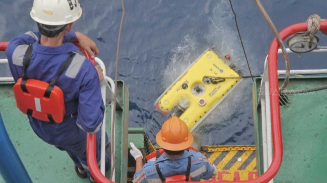 Petugas kru kapal Baruna Jaya 1 menurunkan alat Remote Operated Vehicle (ROV) ke dasar  laut Karawang, Jawa Barat, Minggu (4/11). (Suara.com/Fakhri Hermansyah)