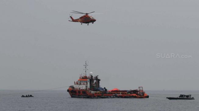 Helikopter Basarnas memantau evakuasi pesawat Lion Air (PK-LQP) JT610 Jakarta-Pangkal Pinang yang jatuh di perairan Tanjung Karawang,Jawa Barat, Minggu (4/11). (Suara.com/Fakhri Hermansyah)