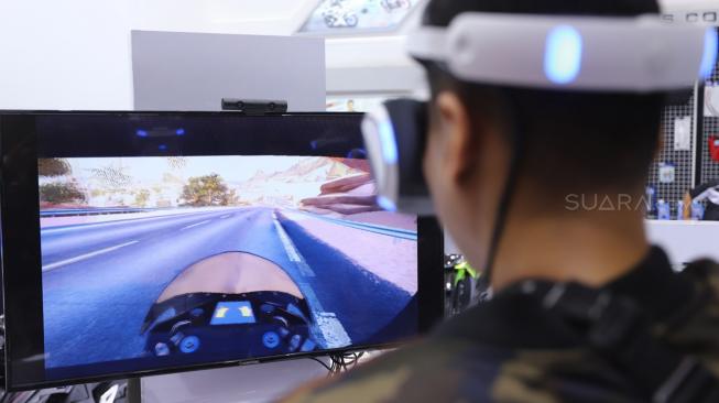 Seorang pengunjung bermain permainan balap motor menggunakan Virtual Reality di VR Corner saat pagelaran Indonesia Motorcycle Show (IMOS) 2018, JCC Senayan, Jakarta, Minggu (4/11/2018). [Suara.com/Muhaimin A Untung] 