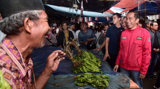 Presiden Joko Widodo berbincang bersama pedagang saat meninjau Pasar Anyar, Tangerang, Banten, Minggu (4/11/2018). [Suara.com/Biro Pers Setpres/Kris]