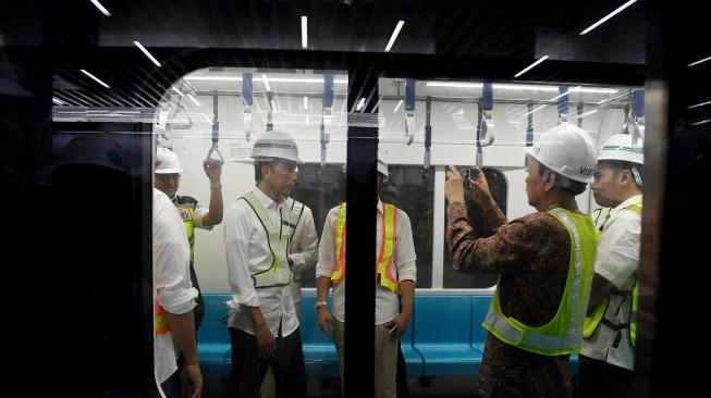 Presiden Joko Widodo (kiri) menaiki kereta Mass Rapid Transit (MRT) Jakarta di Stasiun Bundaran Hotel Indonesia, Jakarta, Selasa (6/11). [ANTARA FOTO/Wahyu Putro]