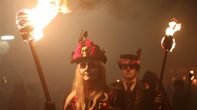 Warga berparade dengan membawa obor dalam perayaan Guy Fawkes Night atau juga disebut Bonfire Night di Lewes, Inggris, Senin (5/11). [AFP/Daniel LEAL-OLIVAS]