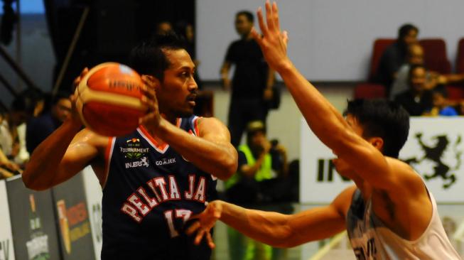 Pebasket Petila Jaya Basketball, Amin Prihantono (kiri), berusaha menghindari hadangan pemain Garuda Bandung, Luke Martinus, pada turnamen Pramusim Indonesian Basketball League (IBL) di Gor Sritex Arena, Solo, Jawa Tengah, Sabtu (20/10/2018). [Antara/Aloysius Jarot Nugroho]